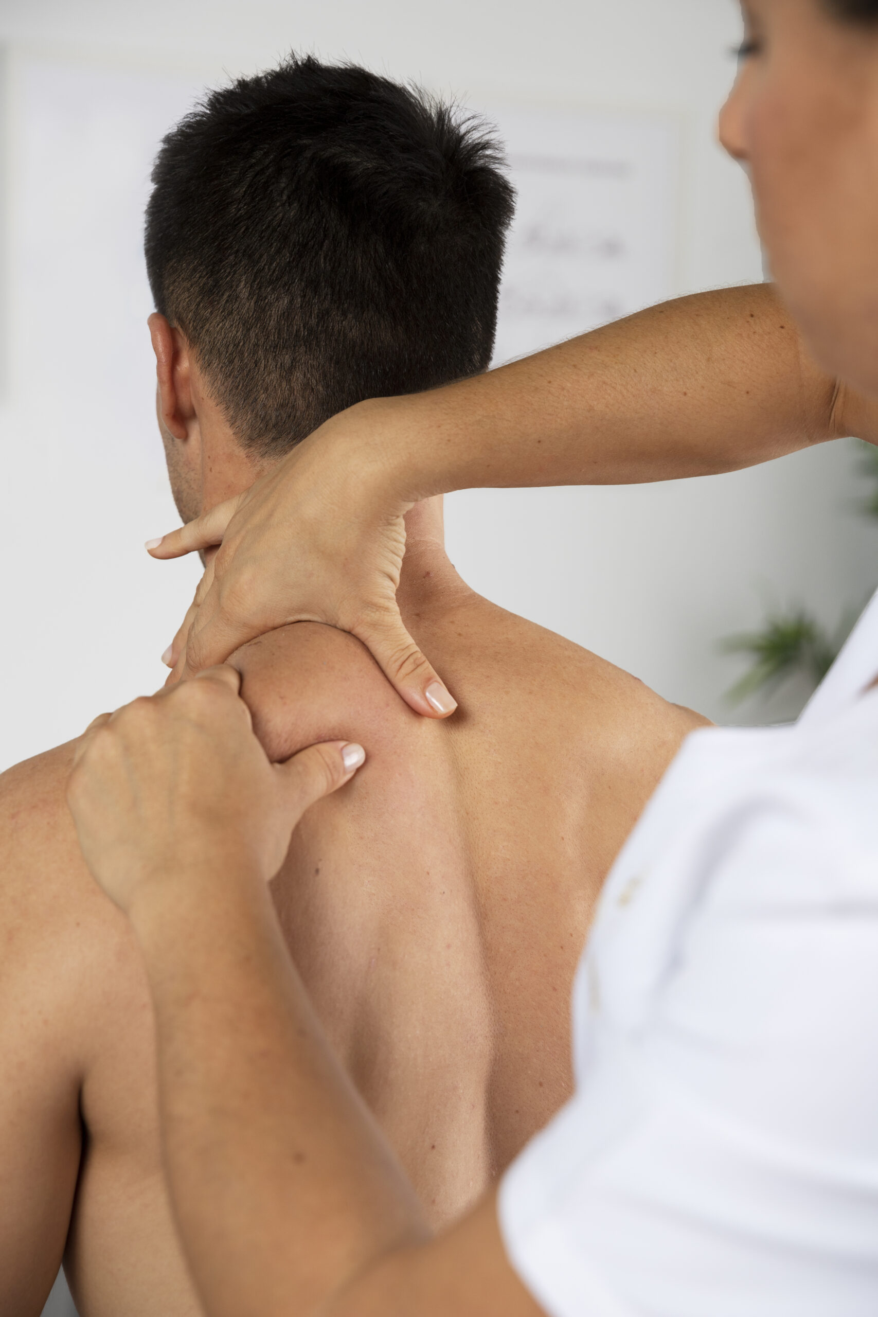 physiotherapist-performing-therapeutic-massage-male-client