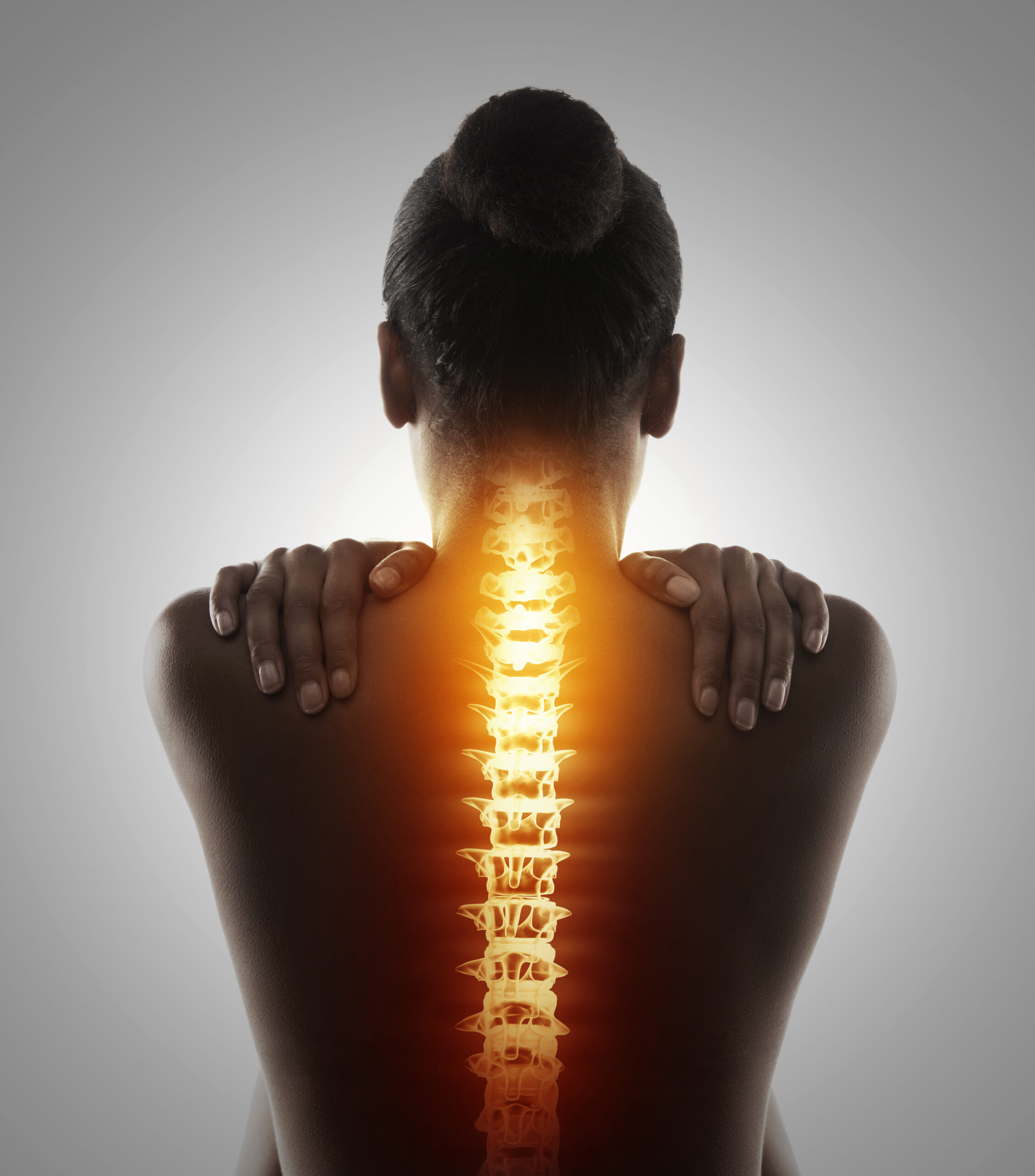 Targeting the pain. Rearview shot of a woman holding her back in